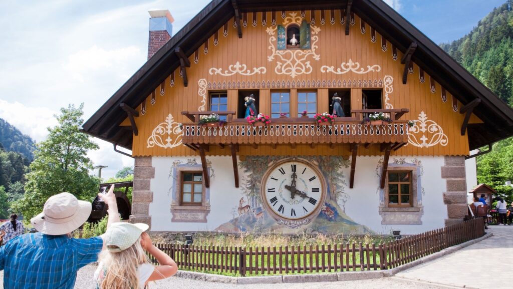 two people standing and looking at a cuckoo clock on a hotel